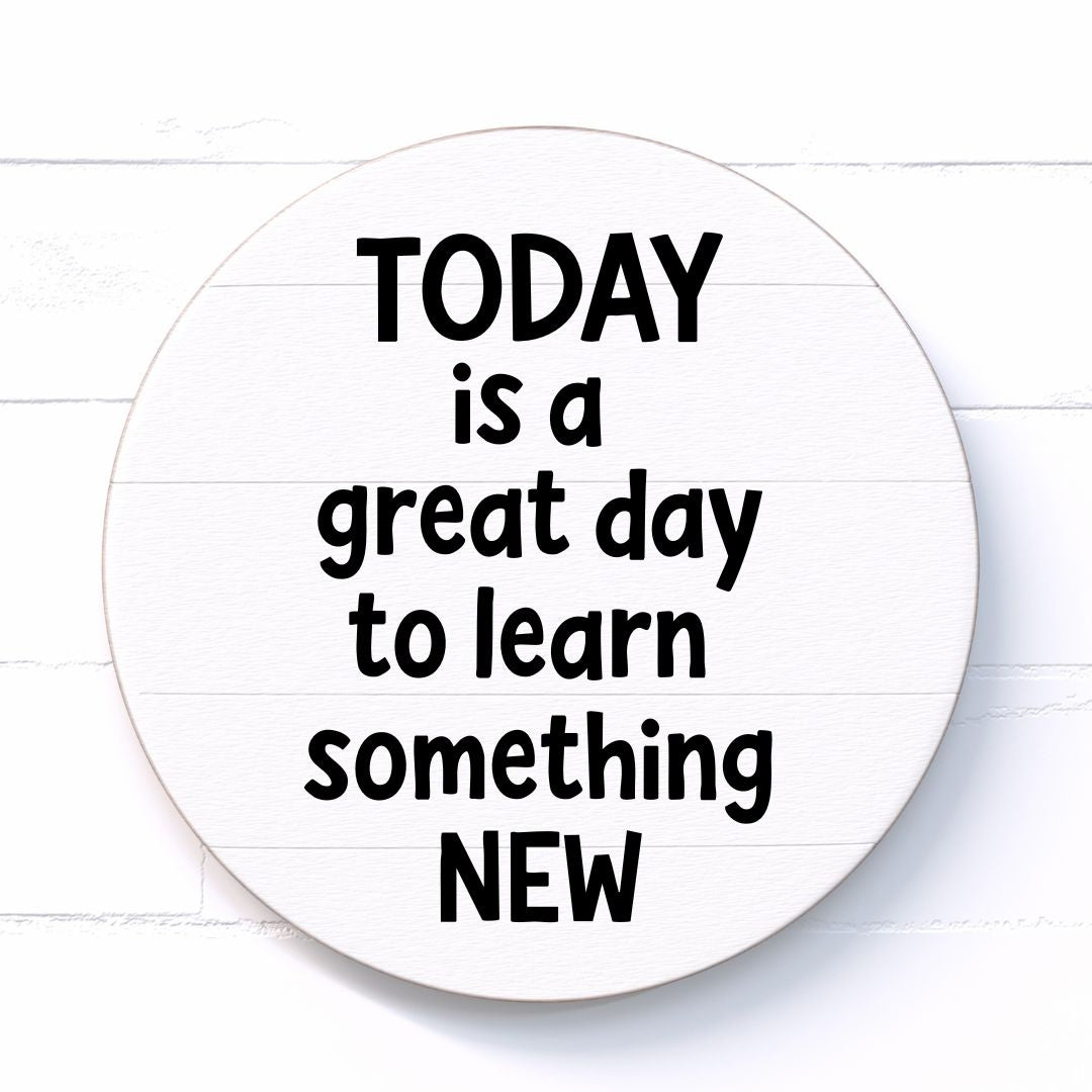 Circular sign with motivational quote "Today is a great day to learn something new" on a white wooden background