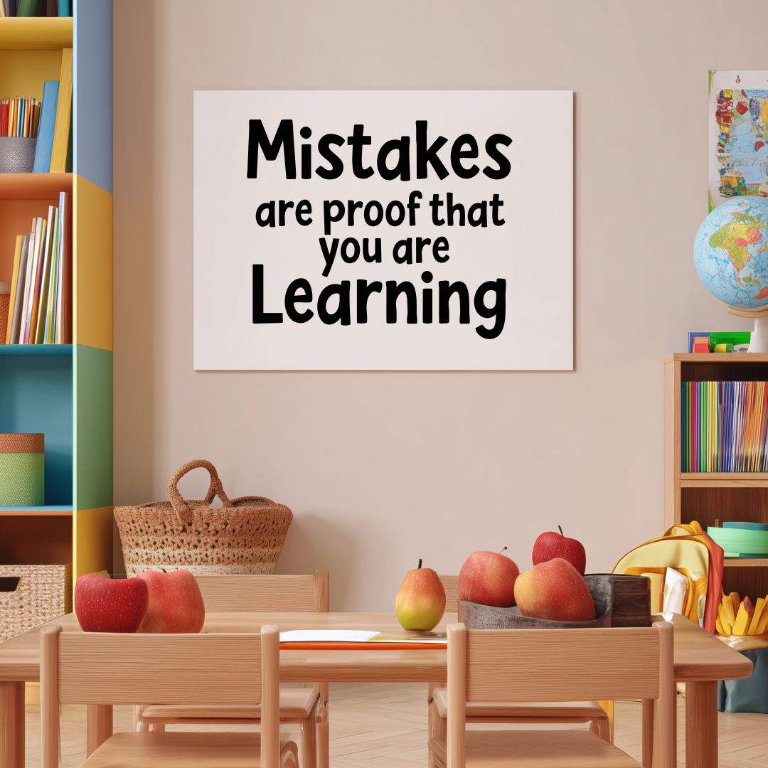 Classroom setting with a motivational poster "Mistakes are proof that you are Learning", books, and apples on a table.