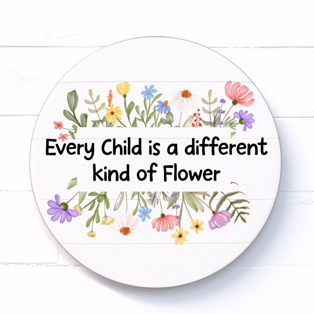 Circular sign with floral design and text stating "Every Child is a different kind of flower" on a white background
