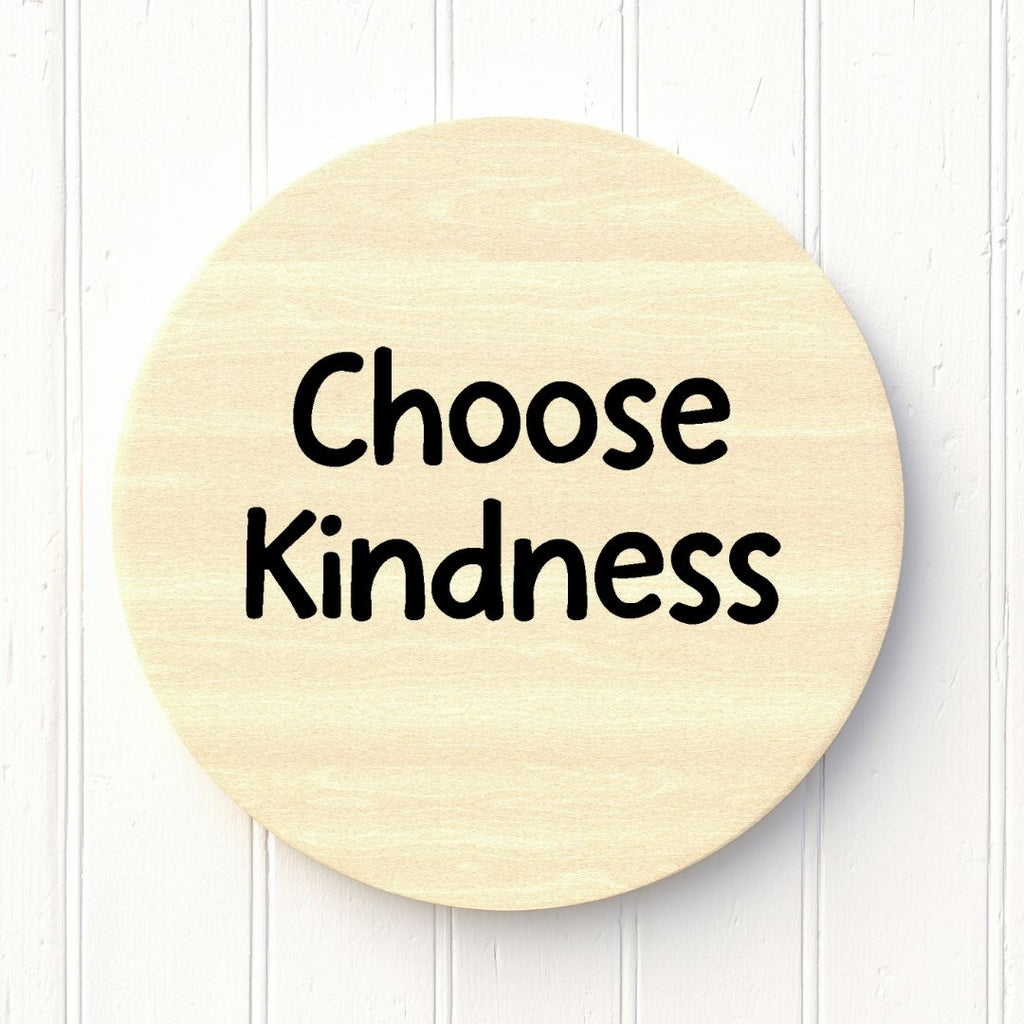 Round wooden sign with 'Choose Kindness' text on a white background