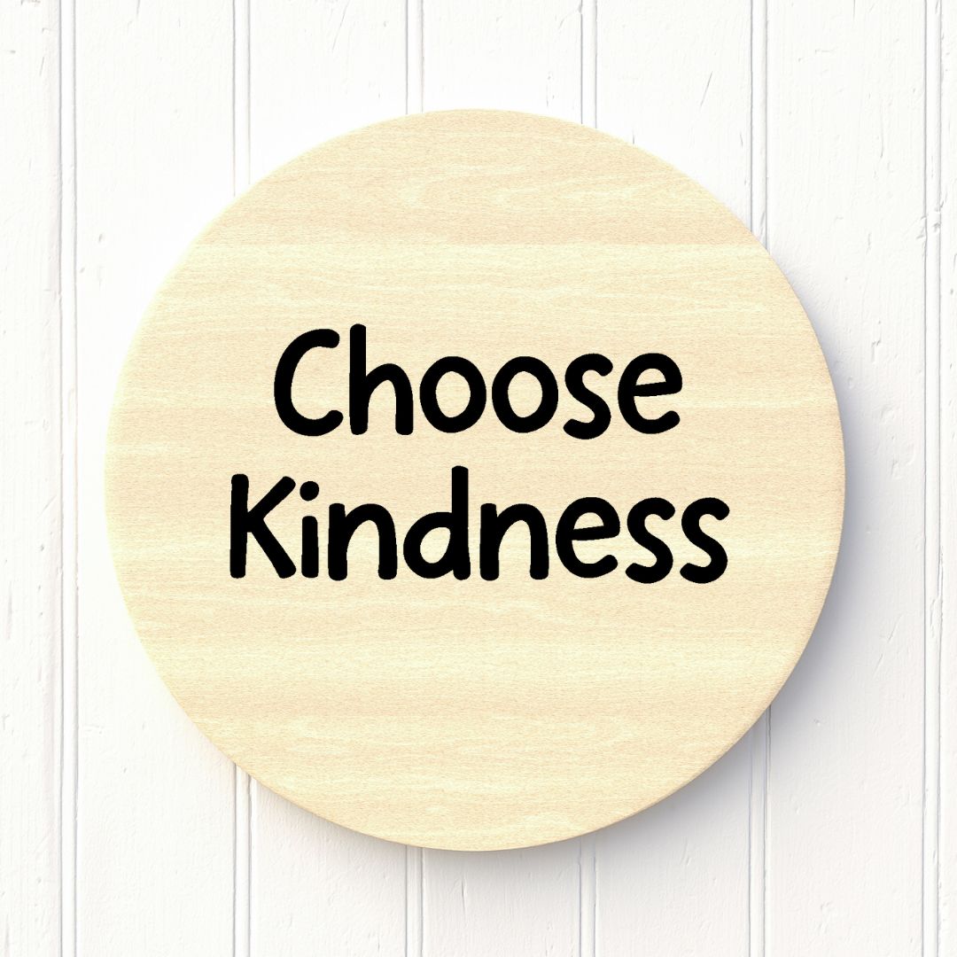 Round wooden sign with 'Choose Kindness' text on a white background