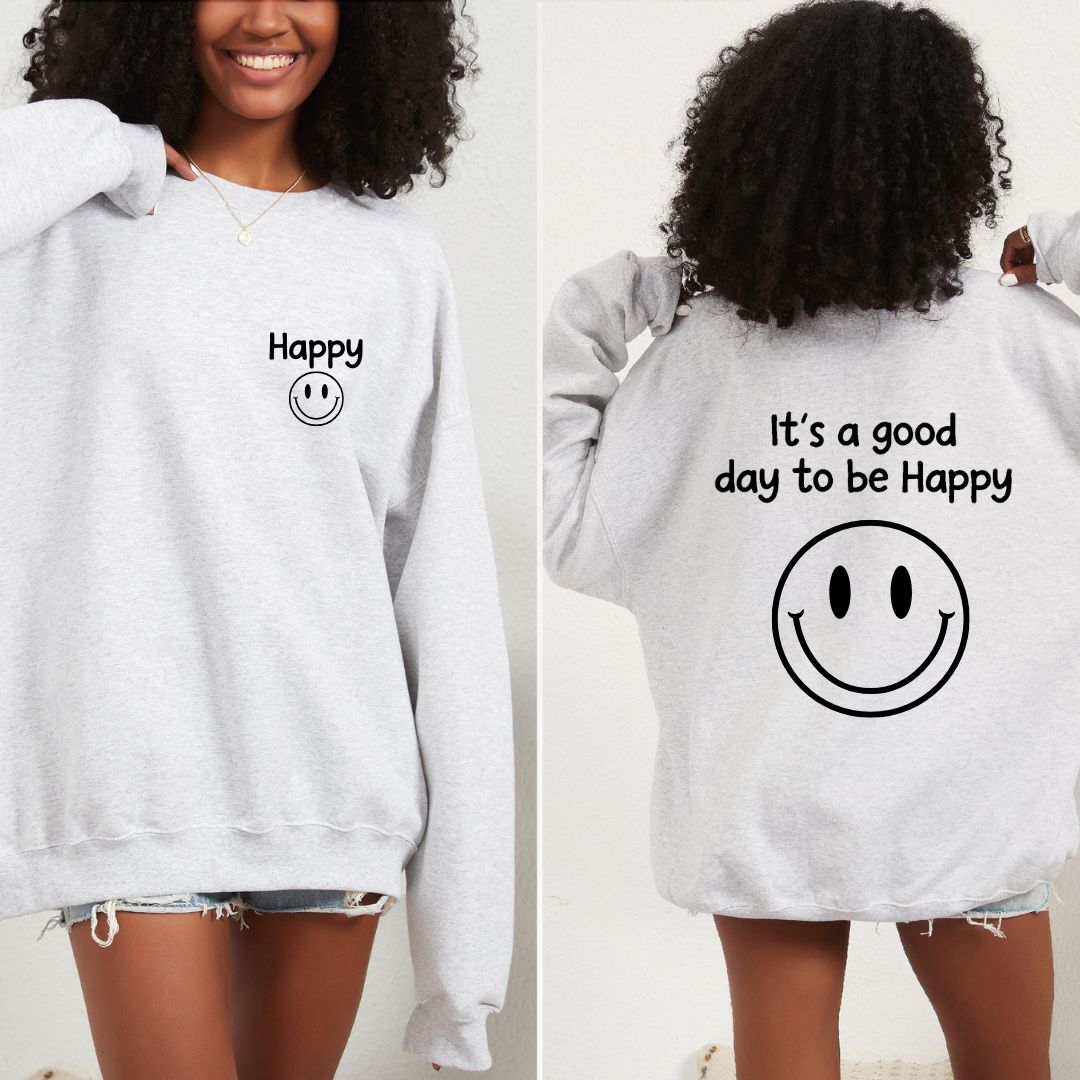 White sweatshirt with smiley face and text that says "It's a good day to be happy" worn by a person, showing front and back views.